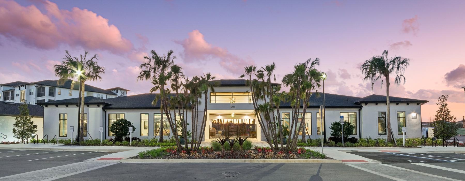 front of a white building with palm trees